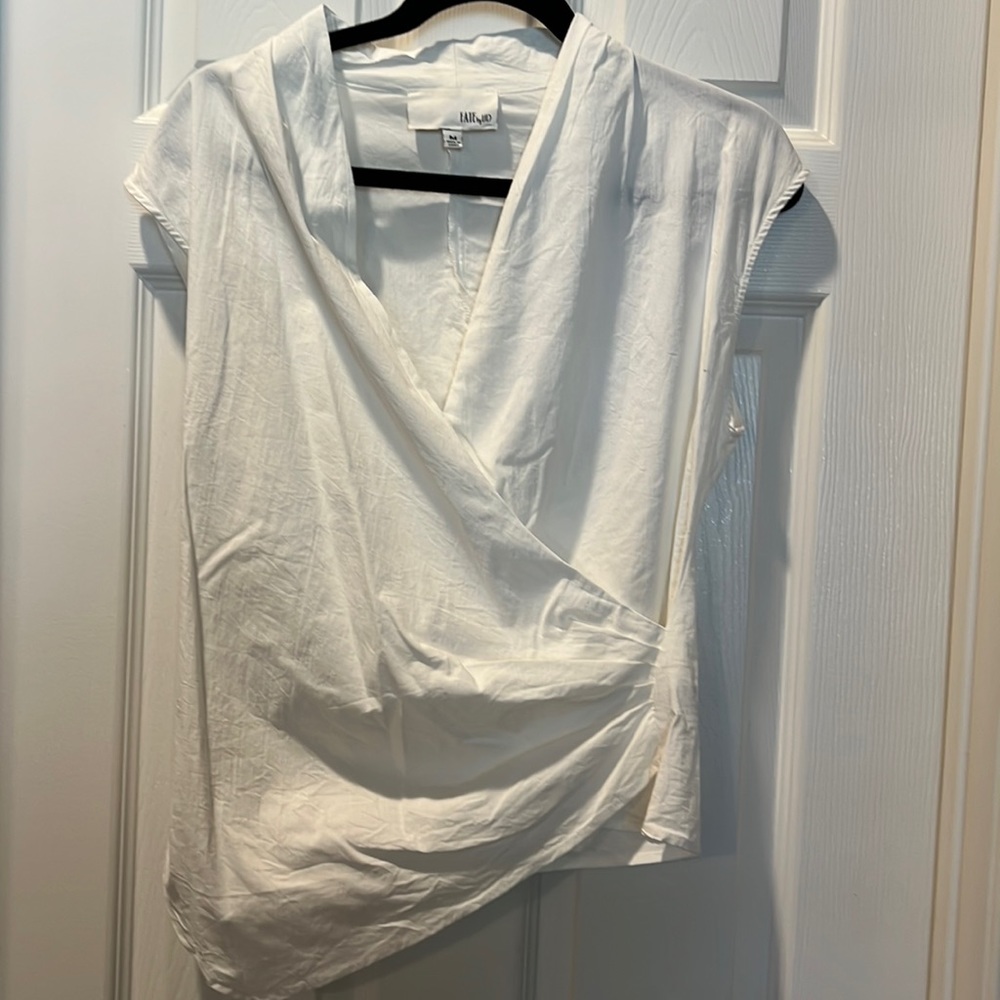 Crisp white asymmetrical cotton blend top.